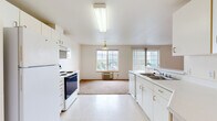 Located at 2055 NE Skyview Dr in Pullman, WA, this 4-bedroom, 2-bathroom residence offers a well-organized single-floor layout designed for comfortable, functional living. The open kitchen and living area form the heart of the unit, where white cabinetry, a electric range, refrigerator, and dishwasher are complemented by light-toned vinyl flooring. A pendant light fixture and dual windows flood the combined space with natural light, providing views of the surrounding area. The living room transitions seamlessly from the kitchen, featuring neutral carpet and a wall-mounted AC unit. Each of the four bedrooms is carpeted and features windows that bring in natural light and outdoor greenery views, along with baseboard heating for year-round comfort. The primary bedroom offers a generous footprint, providing ample space for furnishings. The two bathrooms are appointed with white vanities, tile-patterned flooring, and full bathtub-shower combos. A central hallway connects the bedrooms and bathrooms, contributing to an efficient and accessible floor plan. Throughout the unit, the neutral color palette of cream and white walls creates a clean, bright atmosphere well-suited for a variety of living arrangements.
