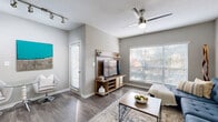 Located along Sidney Marcus Boulevard in Atlanta's vibrant Buckhead neighborhood, this single-floor residence offers a thoughtfully designed layout with a clean, contemporary aesthetic throughout. The living area serves as the heart of the home, featuring wood-style flooring, a ceiling fan, track lighting, and large windows dressed with horizontal blinds that invite generous natural light. A private balcony accessible from the living space offers serene views of mature trees and landscaped greenery.

The kitchen is efficiently arranged with stainless steel appliances, including a range, microwave, and refrigerator, complemented by white cabinetry and light countertops. Wood-style flooring continues here, maintaining a cohesive look throughout the main living areas.

The bedroom is a comfortable retreat finished with plush carpet, a ceiling fan, and a window with sheer curtains that allow soft, diffused light to fill the room. Neutral gray walls throughout the residence create a calm, modern backdrop that complements a variety of décor styles.

The bathroom features a full tub-shower combination with white tile surround, wood-style flooring, and clean, minimal finishes. A dedicated in-unit laundry area provides added everyday convenience with side-by-side washer and dryer connections. Overall, the space balances functional design with a welcoming, contemporary ambiance.