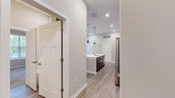 Located at 1 Mossy Grove Ln in Delaware, Ohio, this single-story, 2-bedroom, 2-bathroom home offers a thoughtfully designed open-concept layout with modern finishes throughout. The living room is a standout space, boasting elevated ceilings, light wood-look luxury vinyl plank flooring, and a trio of large windows that flood the room with natural light and offer views of the surrounding greenery. A private exterior door adds convenient access directly from the living area.

The kitchen is a functional centerpiece of the home, featuring dark cabinetry contrasted by crisp white quartz countertops, stainless steel appliances including a refrigerator, range, and microwave, and a large central island with a built-in sink and pendant lighting overhead.

Both bedrooms are carpeted for comfort and include natural light from well-placed windows. The primary bedroom connects to a spacious en-suite bathroom equipped with a double-sink vanity, dark wood cabinetry, a glass-enclosed walk-in shower, and direct access to a walk-in closet with wire shelving. The second bathroom mirrors the modern aesthetic with a single-sink vanity and clean, neutral finishes. Two dedicated closets provide ample storage throughout the home.