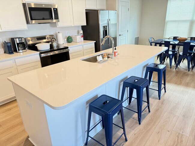 Cocina blanca con encimeras de cuarzo y mucho espacio de almacenamiento. - 122 Grove Hill Ter