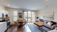 Located at 3240 Whitfield Ave in Cincinnati, Ohio, this single-floor residence offers a thoughtfully designed layout that blends modern finishes with comfortable, functional living. The open-concept living and dining area is bathed in natural light, courtesy of large sliding glass doors that lead to a private balcony overlooking a lush, wooded landscape. The living space features warm wood-look flooring, neutral walls, and vaulted ceiling sections that enhance the sense of openness. The kitchen is well-appointed with crisp white shaker cabinetry, light quartz countertops, a classic subway tile backsplash, and a full suite of stainless steel appliances, including a refrigerator, range, microwave, and dishwasher. Recessed lighting throughout adds a clean, polished feel. The bedroom is a cozy retreat, complete with a ceiling fan, wood-look flooring, and a closet with frosted glass access. The bathroom offers a tiled walk-in shower, a white vanity with ample storage, a large framed mirror, and a charming black-and-white mosaic tile floor. Every detail of this residence reflects a contemporary aesthetic paired with practical design.
