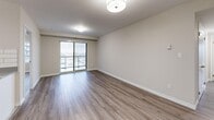 This well-appointed 3-bedroom, 2-bathroom unit at 220 Ira Needles Blvd in Kitchener offers a thoughtfully designed single-floor layout with generous living space. The entrance leads into an open-concept combined living and dining area, finished with warm laminate hardwood flooring and neutral toned walls that create a bright, welcoming ambiance. Sliding doors connect the living area to a private balcony with outdoor views of the surrounding neighbourhood.

The kitchen is outfitted with white cabinetry, grey countertops, a classic subway tile backsplash, and a full suite of stainless steel appliances including a refrigerator, stove, built-in microwave, and dishwasher. Light tile flooring completes the clean, modern aesthetic.

The generously sized primary bedroom features sliding mirrored closet doors and direct access to one of the two bathrooms. The additional bedrooms are well-proportioned, each with laminate flooring and large windows that bring in natural light and outdoor views. The unit includes four closets in total, providing ample storage throughout.

The two bathrooms are finished in a clean, all-white palette — one featuring a walk-in shower and the other a full soaker tub. A dedicated in-unit laundry room adds everyday convenience, rounding out this functional and comfortable home.