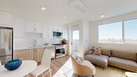 Located at 3943 Oregon Street in San Diego's vibrant North Park neighborhood, this efficiently designed one-bedroom, one-bathroom unit offers a thoughtfully planned open-concept layout. Light wood-tone flooring flows throughout, complementing a clean, modern aesthetic defined by crisp white walls and recessed lighting.

The combined kitchen and living area serves as the heart of the unit. The kitchen is outfitted with white shaker-style upper cabinets, warm wood lower cabinets, white quartz countertops, a subway tile backsplash, and a full suite of stainless steel appliances including a gas range, over-the-range microwave, and dishwasher. The adjacent living area is filled with natural light from large windows that frame sweeping views of the San Diego skyline, and a glass door leads to a private balcony.

The bedroom is a serene retreat bathed in natural light from a generous window overlooking the cityscape. Built-in cabinetry provides smart storage solutions, maximizing the use of the space.

The bathroom features a clean, contemporary design with a full soaking tub and shower combination, white tile surround, warm wood vanity with a white countertop, and wood-look flooring. An in-unit stacked washer and dryer adds everyday convenience to this well-appointed San Diego residence.
