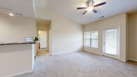 Located at 2600 Silver Thread Ln in Duncan, SC, this one-bedroom, one-bathroom residence offers a well-organized single-floor layout with a thoughtful mix of comfort and functionality. The open-concept living room is a standout feature, boasting soaring vaulted ceilings, a ceiling fan with light kit, and neutral carpet flooring. Natural light filters in through large windows with blinds, and a private exterior door provides convenient outdoor access. Track lighting and high ceilings continue into the entry area, enhancing the spacious feel throughout. The kitchen is efficiently designed with warm honey-toned cabinetry, dark granite-style countertops, wood-look flooring, and black appliances including a range, built-in microwave, and dishwasher. The generously sized bedroom features plush carpet, a vaulted ceiling detail, a window for natural light, and direct access to a dedicated walk-in closet. The full bathroom includes wood-look flooring, warm wood vanity cabinetry, a single-sink vanity with a large mirror, and a tub/shower combination. A separate laundry area with hookups and built-in shelving adds everyday practicality, situated conveniently adjacent to the bathroom.