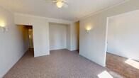 Located at 5730 N Winthrop Ave in Chicago's Edgewater neighborhood, this single-floor unit offers a well-organized layout across a comfortable footprint. The living area is generously proportioned, featuring wall-to-wall carpeting, crown molding, and a ceiling fan with a light fixture. Wall sconces provide warm accent lighting, and a pair of windows along one wall allows natural light to fill the space while offering views of the surrounding cityscape. A cast-iron radiator beneath the windows reflects the building's classic character. A recessed alcove provides a natural nook that could serve as a dedicated workspace or additional storage area.

The kitchen is efficiently designed, finished with white cabinetry that reaches toward the ceiling for ample storage. It is equipped with a gas range, a single-basin sink, open shelving, and a refrigerator, all set atop tile flooring that contrasts with the carpeting in the living area.

The bathroom maintains a classic aesthetic with white subway-style tile wainscoting, a tiled mosaic floor, and a full bathtub with an overhead shower. A wall-mounted vanity with a mirror cabinet and built-in shelving provides practical storage, while a window with blinds allows for natural ventilation and light. The overall ambiance of the unit is clean, bright, and functional, reflecting its timeless Chicago residential character.