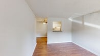 Located at 306 Estes Drive in Carrboro, NC, this single-floor, one-bedroom, one-bathroom unit offers a well-organized layout designed to maximize every square foot. The living room greets you with warm hardwood-style flooring, neutral gray walls, and a textured ceiling that adds dimension to the space. Natural light filters through horizontal-slatted blinds on multiple windows, creating a bright and welcoming atmosphere. A front entry door opens directly into the living area, enhancing accessibility and flow.

The kitchen is open to the living area via a pass-through counter and is efficiently designed with white cabinetry, dark countertops, and a full suite of stainless steel appliances including an electric range, over-the-range microwave, dishwasher, and refrigerator. A ceiling fan with a light fixture provides additional air circulation and lighting throughout the kitchen and adjacent spaces.

The bedroom is a comfortable, carpeted retreat featuring a textured ceiling, a window with natural light, and a closet. Its soft, neutral tones create a calm environment conducive to rest.

The bathroom is clean and functional, featuring a full-size soaking tub with a shower, a curved curtain rod in brushed nickel, and chrome fixtures. The overall design is consistent throughout — simple, neutral, and move-in ready.