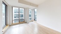 This contemporary 610 square foot apartment in Halifax combines functionality and style in a single-floor layout. The open-concept design seamlessly integrates the living areas, creating a spacious feel enhanced by large windows that flood the space with natural light and offer city views. The modern kitchen boasts sleek white cabinetry, stainless steel appliances, and a subway tile backsplash, perfect for culinary enthusiasts. The bathroom continues the clean aesthetic with a white color scheme, featuring a bathtub-shower combination and marble-look countertops. Light wood flooring throughout adds warmth to the crisp white walls. A standout feature is the sliding barn-style door, adding a touch of character. The apartment also includes a private balcony, ideal for outdoor relaxation. With its thoughtful design and prime location, this apartment offers a perfect blend of urban living and comfort.