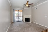 Located at 4717 Grand Ave in Kansas City's renowned Country Club Plaza neighborhood, this single-floor residence combines classic architectural details with modern finishes throughout. Crown molding and ceiling fans are consistent features across the living spaces, contributing to a polished, cohesive aesthetic.

The living room serves as the focal point of the home, anchored by a white-mantled fireplace and neutral carpet. A sliding glass door opens to a private balcony, allowing natural light to fill the space and providing views of the surrounding urban landscape. The transition from carpet to rich hardwood-style flooring marks the entry hall and main circulation areas.

The kitchen is thoughtfully updated, featuring white shaker-style cabinetry extending to the ceiling, granite countertops, stainless steel appliances including a range, microwave, and dishwasher, and a deep undermount sink. Wood-look flooring and under-cabinet lighting enhance its clean, functional design.

The bedrooms are carpeted and finished with crown molding and ceiling fans. Each room includes windows with blinds that admit ample natural light. The bathroom features a soaking tub with tiled surround accented by a dark tile border, complemented by granite countertops and hardwood-style flooring.