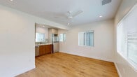 This 420 square foot apartment in Los Angeles offers a thoughtful blend of compact living and modern design. The space consists of one bedroom, one bathroom, and an open-concept living area, all situated on a single floor. The living room is bright and airy, with large windows allowing natural light to flood the space. A ceiling fan provides air circulation, while recessed lighting adds a contemporary touch.

The kitchen is a standout feature, boasting stainless steel appliances, including a refrigerator, stove, microwave, and dishwasher. Two-tone cabinetry in light gray and wood finishes creates visual interest, complemented by a subtle seafoam green tile backsplash. A stacked washer and dryer unit is conveniently tucked into the kitchen area, maximizing space efficiency.

The bedroom, measuring 110 square feet, continues the bright and open feel with a large window and ceiling fan. The bathroom showcases a modern aesthetic with a glass-enclosed shower featuring marble-like tiling and a pebble floor.

Throughout the apartment, warm wood-look flooring unifies the space, creating a cohesive and inviting atmosphere. The neutral color palette of whites and light grays provides a versatile backdrop for personal styling. Despite its compact size, this apartment offers a functional and stylish living solution in the heart of Los Angeles.