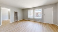 Located at 819 W 137th St in Compton, CA, this single-story 2-bedroom, 1-bathroom home offers a practical and comfortable layout. Light-toned hardwood flooring flows throughout the living spaces and bedrooms, complemented by soft gray walls and white trim that create a clean, cohesive aesthetic. The living room is bright and welcoming, with large windows fitted with vertical blinds that allow generous natural light to fill the space. A hallway connects the main living area to the rest of the home. The combined kitchen and dining area features rich dark-wood cabinetry, a gas range, a sink with countertop workspace, and tile flooring, along with a window and door providing additional light and access. Both bedrooms are well-proportioned, each with its own closet and windows with vertical blinds, offering ample storage and natural light. The primary bedroom provides a comfortable retreat with dedicated closet space. The bathroom is finished with marble-style tile surround on the tub/shower combo and tile flooring, conveying a clean and updated look. Additional storage is provided by three closets and a pantry distributed throughout the home, enhancing its functionality. The layout is efficient and well-connected via a central hallway.