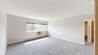 Located at 510 College Ave in Grand Rapids, MI, this single-floor unit offers three bedrooms and one bathroom within a well-organized layout. The spacious primary bedroom features plush carpeting, a built-in closet with warm wood-tone doors, natural light from a wide window with outdoor views, and a wall-mounted air conditioning unit alongside baseboard heating. The two additional bedrooms are similarly carpeted and include baseboard heating, ceiling light fixtures, and windows that bring in natural light. The kitchen stands out as a modern, updated space featuring flat-panel cabinetry in a light wood finish, stainless steel appliances including a refrigerator, range, microwave, and dishwasher, as well as a tile backsplash and light wood-look flooring. The full bathroom is finished with tile flooring in warm earth tones, a tub-shower combination with white tile surround, a vanity with a light countertop, and a mirror. A hallway connects the rooms, contributing to a functional flow throughout the unit. Clean white walls and neutral tones give the space a bright, cohesive aesthetic throughout.