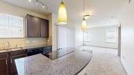 This well-appointed 2-bedroom, 1-bathroom residence in Broomfield, Colorado offers a thoughtfully designed single-floor layout. The open-concept kitchen and living area serves as the heart of the home, anchored by a granite-topped island with pendant lighting and a track-lit ceiling. The kitchen is outfitted with rich dark espresso cabinetry, a tile backsplash, black appliances including a refrigerator and dishwasher, and hardwood-style flooring that adds warmth underfoot. Vertical blinds along a sliding door allow natural light to pour into the adjacent living area, which features soft, plush carpeting throughout.

The primary bedroom is generously sized, featuring dual windows with blinds that invite natural light, and plush carpeting for comfort. The second bedroom is equally well-lit with its own windows and ceiling fan. A dedicated walk-in closet provides ample built-in shelving and hanging space for organized storage. The full bathroom includes tile flooring, a soaking tub with tiled surround accented by decorative diamond tile details, and a frosted-glass entry door. A hallway connects all rooms cohesively, completing this efficient and comfortable floor plan.