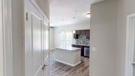 This single-story residence in Leander, TX offers a thoughtfully designed layout across two bedrooms and three bathrooms. The kitchen serves as a central highlight, featuring rich dark-brown cabinetry, granite countertops, a mosaic tile backsplash, and a full suite of stainless steel appliances including a refrigerator, range, microwave, and dishwasher. A peninsula with matching granite provides additional prep space and casual seating. Pendant lighting illuminates the kitchen, which opens toward a sliding glass door that fills the living area with natural light.

Wood-style flooring runs throughout the main living and kitchen areas, lending a cohesive, contemporary feel. Both bedrooms are carpeted and equipped with ceiling fans and windows that bring in natural views. The primary bedroom includes a closet, while the second bedroom offers comparable comfort and natural light. The bathrooms feature wood-style flooring, soaking tub-shower combinations with white tile surrounds, and granite-topped vanities. A hallway connects the living spaces efficiently, completing this functional and modern single-floor layout.
