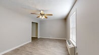 Located at 100 Lewis Dr in Millersville, TN, this single-floor, one-bedroom, one-bathroom unit offers a practical and well-appointed layout. The living area features light wood-look flooring, neutral gray walls, a ceiling fan with integrated lighting, and a wall-mounted HVAC unit. Natural light enters through blinds-equipped windows, contributing to a bright and airy feel. The galley-style kitchen is efficiently designed with dark espresso cabinetry, light countertops, black appliances including a refrigerator, range, dishwasher, and microwave, as well as an integrated laundry area with a full-size washer and dryer. The bedroom is comfortably sized, finished with plush carpeting, a ceiling fan, a closet, and direct access to the bathroom. The bathroom is clean and functional, featuring a single-sink vanity with dark cabinetry, a large mirror with overhead lighting, and a tub-shower combination. Textured ceilings and consistent neutral tones throughout the unit create a cohesive, move-in-ready environment suited for comfortable everyday living.