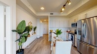Located at 1601 NW 17th Ave in Miami, FL, this thoughtfully designed single-floor residence blends modern finishes with a bright, airy aesthetic throughout. The open-concept living and dining area is anchored by light wood-look flooring, crisp white walls, and a tray ceiling with stylish track lighting that provides both functionality and visual appeal. The kitchen is outfitted with white flat-panel cabinetry, stainless steel appliances including a dishwasher, microwave, and range, as well as sleek quartz countertops and an undermount sink — offering a clean, contemporary workspace. A compact dining area sits adjacent to the kitchen, making the layout ideal for everyday living and entertaining. A hallway connects the main living space to the private bedroom, which features neutral tones, large windows that welcome natural light, and a generous walk-in closet with ample hanging and storage space. The full bathroom is finished with wood-tone vanity cabinetry, a white quartz countertop, a large wall mirror, and subway tile detailing in the shower. A convenient in-unit stacked washer and dryer is tucked behind louvered doors along the hallway. The overall design is cohesive and modern, with a light, neutral palette that creates a calm and inviting atmosphere throughout.