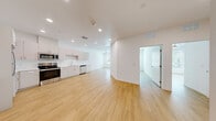 Located at 4850 W Rome Blvd in Las Vegas, NV, this 2-bedroom, 1-bathroom unit offers a clean, modern aesthetic throughout. Light wood-style flooring extends seamlessly across all living areas, creating a cohesive and bright interior. The open-concept living and kitchen area is a standout feature, offering generous room to move and entertain. The kitchen is thoughtfully designed with light gray flat-front cabinetry, ample counter space, and a full suite of stainless steel appliances including a refrigerator, range, microwave, and dishwasher. Recessed lighting illuminates the space efficiently overhead. Both bedrooms are well-proportioned, featuring crisp white walls, the same warm wood-tone flooring, and large windows dressed with horizontal blinds that invite natural light and outdoor views. One bedroom includes a ceiling fan for added comfort. The bathroom maintains the home's clean, contemporary style with a white vanity, undermount sink, large mirror, and a combined tub and shower. A dedicated closet provides practical storage. The unit's consistent use of neutral tones, recessed lighting, and modern finishes creates a bright, functional, and move-in-ready living space.