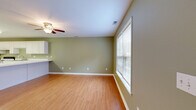 Located at 375 E Baskins Rd in Rock Hill, SC, this two-story home offers a well-organized layout spread across two floors. The main level features a bright living room with warm hardwood-style flooring, a ceiling fan, and large windows fitted with blinds that allow ample natural light. A classic wood-railed staircase with white balusters connects both floors. The kitchen is equipped with white cabinetry, white appliances including a refrigerator, range, and dishwasher, a double sink, and tile flooring. A generous peninsula with a white countertop provides additional prep space and informal dining. A pendant chandelier adds a decorative touch overhead. The upper level hosts two bedrooms, each with hardwood-style flooring, ceiling fans, and natural light from windows. The spacious primary bedroom includes a double-door closet, while the second bedroom also features a closet for ample storage. Both bathrooms are finished in light, neutral tones — one includes a white vanity and towel ring, and the other features a full soaking tub with a shower surround and chrome fixtures. A dedicated laundry area and utility room add practical convenience. With four closets throughout, this home offers notable storage capacity.