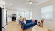 Located at 5476 Angel Way in Saint Cloud, FL, this single-story, 3-bedroom, 2-bathroom home offers a clean, modern design characterized by crisp white walls, light wood-style flooring, and an abundance of natural light throughout. The open-concept living and kitchen area serves as the heart of the home, featuring a ceiling fan, pendant lighting over a breakfast bar, stainless steel appliances, white cabinetry, and multiple windows that bring in generous outdoor light. The seamless flow between the living and kitchen spaces makes the area feel airy and welcoming. Each bedroom is well-proportioned and bright, with large windows, ceiling fans, and closet access. The primary bedroom is a comfortable retreat, offering notable square footage, natural light from dual windows, and a spacious walk-in closet outfitted with wire shelving for ample storage. The additional bedrooms are versatile and equally light-filled, suited for sleeping quarters, a home office, or a creative space. Both bathrooms maintain the home's clean aesthetic, featuring white vanities with quartz-style countertops, large mirrors, and modern brushed nickel fixtures. Hallways connect each area efficiently, completing a thoughtful, functional floor plan ideal for everyday living.