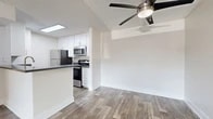 Located at 2235 W Broadway in Anaheim, CA, this single-story, one-bedroom, two-bathroom unit offers a well-organized and functional layout. The open-concept living, dining, and kitchen area forms the heart of the home, with wood-look flooring throughout and a textured ceiling with a ceiling fan providing comfort and style. A skylight brightens the kitchen area, which is equipped with stainless steel appliances—including a refrigerator, range, and microwave—white cabinetry, subway tile backsplash, and a dark countertop peninsula with a sink, ideal for both cooking and casual dining. The living and dining area is open and bright, with clean white walls and ample room to arrange furniture comfortably. The bedroom features soft carpeting, a sliding closet for storage, and a window that invites natural light and outdoor views. Two full bathrooms, including one with a tub/shower combination, serve the unit. Two closets provide additional storage throughout. A private patio rounds out the unit, offering outdoor space. The overall ambiance is clean, modern, and move-in ready, with a neutral palette that suits a variety of furnishing styles.