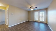 Located at 705 Walnut Ridge Dr in Duquesne, Missouri, this single-floor residence offers a well-organized layout designed for comfortable everyday living. The main living area makes a strong impression with rich, dark hardwood-style flooring, warm neutral walls, and a ceiling fan with integrated lighting. A set of French doors floods the space with natural light and opens to an outdoor balcony, extending the living area beyond its interior boundaries.

The galley-style kitchen is outfitted with dark cabinetry, granite-look countertops, and black appliances including a refrigerator, electric range, microwave, and dishwasher. The efficient layout maximizes counter and storage space throughout.

The bedrooms feature plush carpeting and natural light from window openings fitted with blinds. Each room includes generous closet space, with wire shelving systems for organized storage. The primary bedroom benefits from direct access to additional spaces, including a walk-in closet area.

Two bathrooms serve the residence, each finished with dark vanity cabinetry, granite-look countertops, and wood-look tile flooring. One bathroom includes a full tub and shower combination, while the other offers a dedicated vanity and toilet area.

A dedicated laundry room with hardwood-style flooring, washer/dryer hookups, and overhead shelving adds everyday convenience. The overall aesthetic is clean, cohesive, and move-in ready.