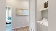 This single-story, 2-bedroom, 2-bathroom home offers a bright and modern living environment with a cohesive design aesthetic throughout. Light-toned wood-look flooring runs through the main living areas, complementing the neutral wall palette and creating a clean, welcoming ambiance.

The kitchen is a standout feature, equipped with stainless steel appliances including a range, microwave, dishwasher, and refrigerator. White cabinetry with brushed nickel hardware pairs with gray quartz-style countertops, and a center island with bar seating adds both functionality and style. Large windows allow abundant natural light to fill the space.

The living room is comfortably sized, featuring sliding glass doors that open to an outdoor patio area, bringing in natural light and providing easy access to the exterior. The entrance includes in-unit laundry, adding everyday convenience.

The primary bedroom is generously proportioned, offering a large window with outdoor views, a ceiling fan, and ample closet space. The second bedroom also includes a built-in closet. Both bathrooms are well-finished — the primary bath features a walk-in glass shower, extended vanity with gray countertops, and wood-look flooring, while the second bathroom offers a shower-tub combo with a similarly styled vanity. The overall design is cohesive, functional, and move-in ready.
