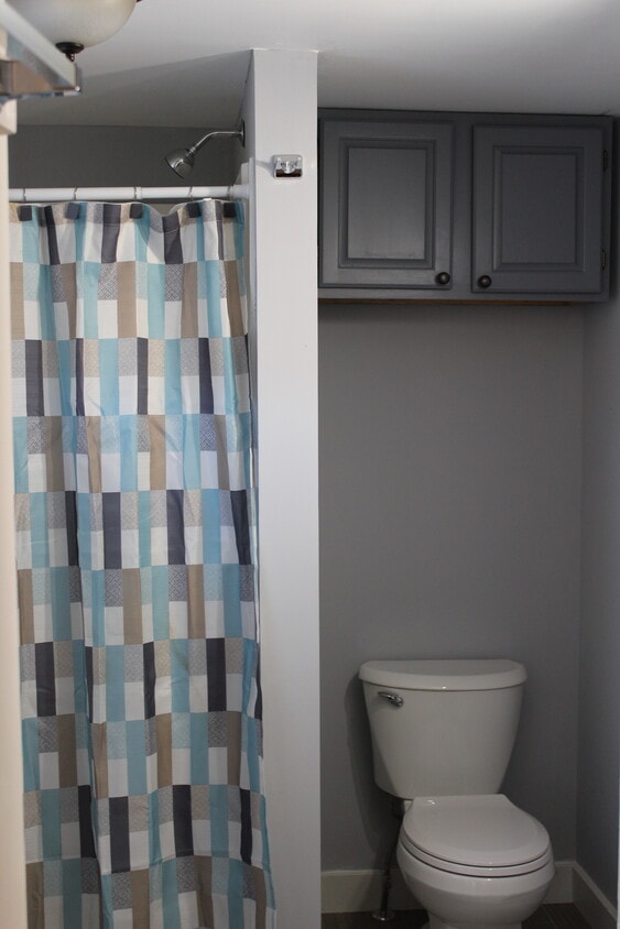 Bathroom has large shower stall. Storage above toilet. - 1011 Main St