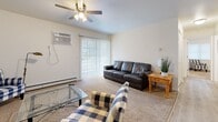 This single-floor, 3-bedroom, 1-bathroom unit offers a well-organized layout designed to maximize functionality. The carpeted living room serves as a comfortable central gathering space, featuring a ceiling fan, a wall-mounted air conditioning unit, and a sliding glass door that invites natural light and provides outdoor access. A dedicated dining area adjacent to the living space offers a cozy setting for meals, accented by light hardwood-style flooring that continues into the kitchen. The galley-style kitchen is efficiently designed with white cabinetry, dark granite countertops, stainless steel appliances including a refrigerator, range, dishwasher, and microwave, along with a deep utility sink. The three bedrooms are carpeted and offer a quiet, comfortable atmosphere, each with neutral walls and adequate natural light. The primary bedroom provides a generous amount of space. The full bathroom features light hardwood-style flooring, a white vanity with stone countertop, and a shower-tub combination. A dedicated laundry area adds everyday convenience. Overall, the unit presents a clean, practical living environment suited for a variety of lifestyles.