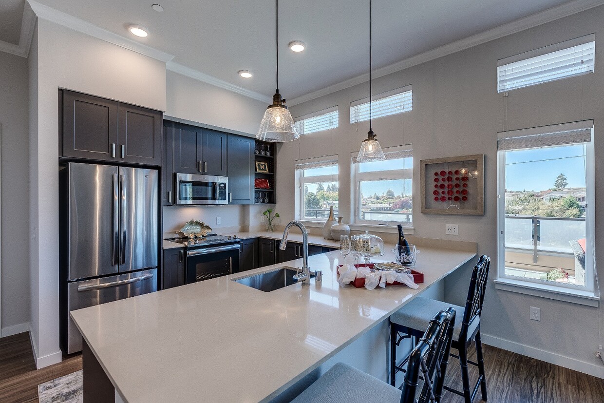 Lux Apartments offers spacious kitchens with dark walnut or arctic white cabinet finishes, stainless steel appliances, inset/undermount sinks, and quartz countertops - Lux