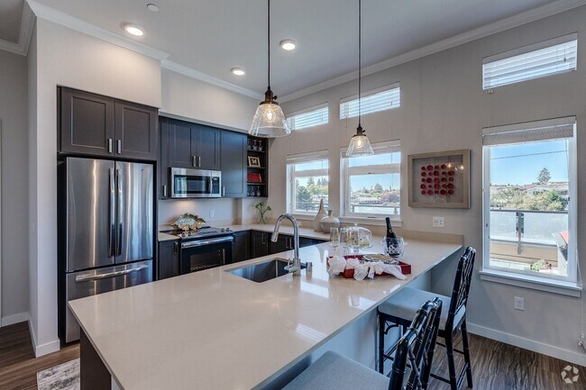 Lux Apartments offers spacious kitchens with dark walnut or arctic white cabinet finishes, stainless steel appliances, inset/undermount sinks, and quartz countertops - Lux