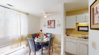 This two-story townhome in Memphis, Tennessee offers a practical and well-organized layout across two floors. The main level features a dining area and kitchen situated in close proximity, creating a convenient flow for everyday living. The dining space is brightened by natural light from a window dressed with sheer curtains and features a ceiling fan overhead, checkered tile flooring, and a two-tone wall treatment with a warm golden lower half. The adjacent kitchen is equipped with white cabinetry extending to the ceiling, ample counter space, a stainless steel sink, and an electric range, providing solid functionality for cooking and meal preparation.

The two bedrooms are carpeted and offer a comfortable sense of scale, each featuring windows that allow natural light to filter in. One bedroom includes a sliding-door closet, providing useful storage. The full bathroom includes a tub and shower combination with tile-patterned flooring, maintaining a clean and straightforward design. A staircase connects the two floors, allowing for clear separation between living and sleeping areas. Overall, the townhome presents a straightforward, livable layout suited for everyday comfort.