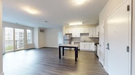 Located at 150 Glover Ave in Norwalk, CT, this well-appointed 2-bedroom, 2-bathroom residence offers a thoughtfully designed layout with modern finishes throughout. The open-concept kitchen and living area serves as the heart of the home, featuring white shaker cabinetry, granite countertops, a central island, and a full suite of stainless steel appliances including a gas range, dishwasher, microwave, and refrigerator. Rich wood-tone flooring runs throughout the space, lending warmth and cohesion to the interior. The living area is bright and inviting, with sliding glass doors that open onto a private balcony overlooking a landscaped courtyard and community pool. Both bedrooms are generously sized and filled with natural light from large windows. The spacious primary bedroom offers ample room for a full furniture arrangement. Each bathroom is finished with white cabinetry, quartz countertops, and large vanity mirrors. The primary bath features a dual-sink vanity with abundant storage. A hallway connects the living spaces to the bedrooms and bathrooms, providing a clean and functional flow throughout this modern Norwalk residence.