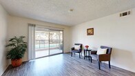 This two-bedroom, two-bathroom residence in Redlands, CA offers a well-organized single-level layout designed for comfortable everyday living. The open living and dining area is anchored by durable wood-look flooring that extends throughout the home, while a textured ceiling adds classic character. Large sliding glass doors in the living room flood the space with natural light and open directly onto a private balcony, offering pleasant outdoor views. A dedicated dining area sits adjacent to the living space, providing a natural flow for entertaining. The galley-style kitchen features white cabinetry, light granite-style countertops, a gas range, and ample storage on both sides, maximizing efficiency within a compact footprint. Both bathrooms are finished with white vanities, granite-style countertops, large mirrors, and combination tub-shower units, maintaining a clean and cohesive aesthetic. Each bedroom offers a bright, neutral environment with natural light provided by slatted windows and wood-look flooring underfoot. The primary bedroom is a comfortable size and includes convenient closet access. A connecting hallway ties the bedrooms and bathrooms together seamlessly. The overall ambiance is light, clean, and functional — well-suited to those seeking a practical home in the Redlands community.