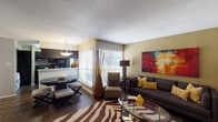 Located in Houston's 77008 zip code, this single-floor residence offers a thoughtfully designed layout that balances comfort and style. The living room serves as the centerpiece of the home, featuring rich hardwood-style flooring, a bold zebra-print area rug, and warm earth-toned walls accented by a vibrant large-scale abstract artwork. A dark upholstered sofa, coordinating accent chairs, and a glass-top coffee table complete the space, while wide windows with horizontal blinds invite ample natural light throughout.

The kitchen is outfitted with dark cabinetry, light granite countertops, stainless steel appliances, and a window that provides additional brightness. A dining area with pendant lighting sits adjacent, offering a seamless flow between cooking and entertaining spaces.

The primary bedroom features plush carpeting, a ceiling fan with light fixture, and a bold navy accent wall that adds depth and character. The second bedroom is equally well-appointed with carpeted floors, natural light from a large window, and generous storage via a dark wood armoire.

Both bathrooms are finished with hardwood-style flooring, dark vanity cabinetry, and shower-tub combinations. The unit also includes in-unit laundry, adding everyday convenience to this well-rounded Houston home.