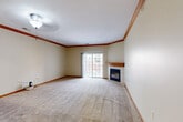 Located at 17131 Frances Plaza in Omaha, Nebraska, this well-appointed one-bedroom, one-bathroom residence offers a thoughtfully designed single-floor layout with generous living space throughout. The open-concept living room serves as the heart of the home, showcasing plush wall-to-wall carpeting, warm wood crown molding, and a handsome fireplace with a tile surround and oak mantel. A sliding glass door floods the room with natural light and provides access to the outdoors. The adjacent kitchen features a classic U-shaped configuration with rich oak cabinetry, ample counter space, tile flooring, and a full suite of appliances including a range, microwave, and refrigerator. The spacious primary bedroom is generously sized, complete with a ceiling fan and plush carpeting, and connects to a large walk-in closet with built-in shelving and hanging rods for abundant storage. The full bathroom offers a clean, functional design with a combined tub and shower, vanity with sink, and tile flooring. A dedicated laundry area with washer hookups and overhead shelving adds everyday convenience. Warm neutral tones and wood trim details throughout lend the space a cohesive, inviting ambiance.