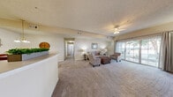 Located in Spring Hill, Tennessee, this single-story, 3-bedroom, 2-bathroom home offers a well-organized and comfortable layout. The open-concept living room is carpeted and bathed in natural light, featuring a ceiling fan and large sliding glass doors that lead to a private outdoor patio with views of mature trees. The adjacent dining area is defined by an elegant chandelier overhead, creating a cozy space for meals. The kitchen is outfitted with warm oak cabinetry, white appliances including a range, built-in microwave, and refrigerator, all set atop easy-care hard-surface flooring. The primary bedroom is a generously proportioned retreat with plush carpeting, natural light from multiple windows with draping curtains, and access to a walk-in closet equipped with wire shelving. The additional bedrooms are equally well-lit and carpeted. The bathrooms feature tile flooring, with one including a full tub-shower combination. Throughout the home, neutral tones and a textured ceiling create a cohesive, warm ambiance that is both inviting and functional — ideal for everyday living in a quiet Spring Hill community.