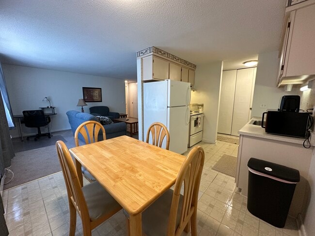 Dining Table with dishes and cookware to feel at home. - Avalon Apartments