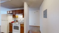 Located in Albertville, Minnesota, this 2-bedroom, 1-bathroom single-floor unit offers a functional and well-organized layout. The open-concept living, dining, and kitchen area forms the heart of the space, with durable hardwood-style flooring in the kitchen and plush carpeting in the living area. The kitchen is equipped with warm oak cabinetry, a double-basin sink, ample counter space, and white appliances including a range and dishwasher. A textured ceiling runs throughout the unit, adding a classic residential character.

The living room is bright and inviting, featuring a sliding glass door that allows natural light to pour in and provides a view of the outdoors. Baseboard heating is present throughout the unit, ensuring comfort during Minnesota's colder months.

Both bedrooms are carpeted and feature natural light from windows with vertical blinds. The unit includes an impressive five closets in total, including a spacious walk-in closet with wire shelving and hardwood-style flooring—providing exceptional storage for a unit of this size.

The full bathroom is well-appointed with a wood-toned vanity with drawers, a single-basin sink, a tub-shower combo with a handheld showerhead, grab bars for added accessibility, and tile flooring. A hallway connects the main living areas to the bedrooms and bathroom, completing this practical and comfortable layout.