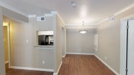 This single-story, two-bedroom, two-bathroom residence offers a thoughtfully designed layout with consistent finishes throughout. Rich, dark wood-style flooring runs through the living areas, bedrooms, and bathrooms, complemented by crisp white crown molding and neutral taupe walls that create a cohesive, welcoming ambiance.

The living area is bright and open, featuring a textured ceiling, crown molding, and a window with blinds that allows natural light to fill the space. A pendant light fixture anchors the dining area, which connects seamlessly to the kitchen via a pass-through opening. The kitchen is well-equipped with granite countertops, white cabinetry, a classic subway tile backsplash, stainless steel sink, and black appliances including a refrigerator, range, and dishwasher.

Both bedrooms are generously sized, each featuring ceiling fans with lighting, windows with exterior views, and access to closet space. One bedroom includes a walk-in closet and direct access to a full bathroom. Both bathrooms are outfitted with tub-shower combinations with tiled surrounds. One bathroom features a dark-framed vanity mirror with overhead lighting, while the other offers a clean, white-toned aesthetic with ample storage.