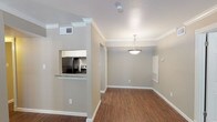 This single-story, two-bedroom, two-bathroom residence offers a thoughtfully designed layout with consistent finishes throughout. Rich, dark wood-style flooring runs through the living areas, bedrooms, and bathrooms, complemented by crisp white crown molding and neutral taupe walls that create a cohesive, welcoming ambiance.

The living area is bright and open, featuring a textured ceiling, crown molding, and a window with blinds that allows natural light to fill the space. A pendant light fixture anchors the dining area, which connects seamlessly to the kitchen via a pass-through opening. The kitchen is well-equipped with granite countertops, white cabinetry, a classic subway tile backsplash, stainless steel sink, and black appliances including a refrigerator, range, and dishwasher.

Both bedrooms are generously sized, each featuring ceiling fans with lighting, windows with exterior views, and access to closet space. One bedroom includes a walk-in closet and direct access to a full bathroom. Both bathrooms are outfitted with tub-shower combinations with tiled surrounds. One bathroom features a dark-framed vanity mirror with overhead lighting, while the other offers a clean, white-toned aesthetic with ample storage.