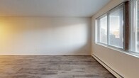 Located at 2585-2613 Conway Ave E in Maplewood, Minnesota, this one-bedroom, one-bathroom unit offers a practical and well-appointed single-floor layout. The combined kitchen and living area serves as the heart of the unit, featuring warm wood-style vinyl flooring, a ceiling fan with light fixture, and a textured ceiling. The kitchen is outfitted with gray shaker-style cabinetry, granite-look countertops, a double-basin sink, and black appliances including a range and refrigerator, with upper and lower cabinet storage providing generous workspace. The open living area flows naturally from the kitchen, creating a functional shared space. The bedroom is a comfortable, well-lit room featuring wood-style flooring, a baseboard heating unit, a window with blinds that brings in natural light, and a ceiling fan. A wall-mounted AC unit provides additional climate control. The bathroom includes a full tub-shower combo with a white surround, a toilet, and a medicine cabinet with mirror. Throughout the unit, three closets offer exceptional storage capacity. Clean finishes, neutral tones, and consistent flooring throughout give this unit a cohesive, move-in-ready appearance.