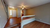 Located at 9320 South College Avenue in Tulsa, Oklahoma, this two-story home offers a well-organized layout across both levels. The main living area greets visitors with warm hardwood flooring, a ceiling fan, and a classic fireplace, creating a comfortable and inviting atmosphere. A staircase with a white-spindle railing connects the levels, adding a traditional architectural touch.

The galley-style kitchen is efficiently designed with rich wood cabinetry, dark countertops, and a full suite of black appliances including a refrigerator, electric range, microwave, and dishwasher. Track lighting illuminates the space, while hardwood floors carry through for easy maintenance.

The bedrooms are carpeted for comfort and feature ceiling fans and windows that allow natural light to fill each room. The vaulted ceiling in the primary bedroom adds a sense of openness, while an adjoining bathroom offers a double-sink vanity with wood cabinetry and ample counter space. A secondary bathroom includes a tub-shower combination with hardwood flooring and a single vanity. Throughout the home, warm neutral tones on the walls complement the wood finishes, creating a cohesive and functional living environment suited for everyday comfort.