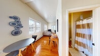 Located at 1841 N Third St in Harrisburg, PA, this single-floor studio offers a well-designed open layout that efficiently combines living, sleeping, dining, and kitchen functions in one cohesive space. Warm hardwood floors flow throughout, complementing the neutral color palette and creating a bright, inviting atmosphere.

The vaulted ceilings add a sense of generous vertical space, while multiple windows — including a striking arched window in the kitchen area — flood the interior with abundant natural light. The kitchen is equipped with warm wood cabinetry, a full-size refrigerator, stove, microwave, and a double sink, making it both functional and visually appealing.

The sleeping area is clearly defined within the open floor plan and features tall walls that enhance the airy feel of the space. A dedicated living area with room for seating and a television is positioned near the windows, benefiting from the natural light and an open, relaxed ambiance. A compact dining area sits adjacent to the kitchen, offering a practical space for everyday meals.

The bathroom features warm golden tile flooring, a pedestal sink, and a shower, finished with cheerful yellow-toned walls that add a pop of color. Throughout the unit, the thoughtful use of space, ample light, and architectural details such as the arched window make this a distinctive and practical residence in Harrisburg.