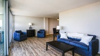 Located at 330 W Brambleton Ave in Norfolk, Virginia, this single-floor residence offers a thoughtfully designed layout with a blend of comfort and functionality. The expansive living room features light wood-style flooring and floor-to-ceiling sliding glass doors that open onto a private balcony, filling the space with abundant natural light and providing views of the surrounding cityscape. The living area flows seamlessly into a dedicated dining space, complete with a ceiling fan and room for a full dining set. The galley-style kitchen is efficiently organized with white shaker cabinetry, granite-style countertops, a subway tile backsplash, stainless steel appliances including a gas range and dishwasher, and matching wood-style flooring. Two well-sized bedrooms feature plush carpeting and windows that invite natural light. The primary bedroom offers generous proportions and direct access to a bathroom appointed with white cabinetry, granite-style countertops, a large vanity mirror, and wood-style flooring. The neutral color palette and clean finishes throughout create a bright, welcoming ambiance suited to a variety of lifestyles.