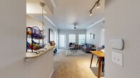This single-floor, 2-bedroom, 2-bathroom residence is thoughtfully designed to maximize comfort and functionality. The open-plan living and dining area serves as the heart of the home, featuring plush carpet flooring, crown molding, and a ceiling fan. Large windows along the exterior wall flood the space with natural light and offer outdoor views, while a track lighting system and pendant fixtures provide additional illumination. The living area connects seamlessly to a dedicated dining space.

The kitchen features light wood cabinetry, granite-style countertops, tile flooring, and a peninsula that opens toward the dining area — ideal for both cooking and entertaining. A pantry and in-unit laundry area add to the home's practicality.

The primary bedroom is generously sized, highlighted by an arched window that brings in ample natural light, carpet flooring, and a ceiling fan. It is complemented by a private en-suite bathroom with a walk-in shower, tile flooring, and a spacious walk-in closet fitted with wire shelving systems. The second bedroom is equally well-appointed with its own ceiling fan and comfortable proportions. A second full bathroom with a glass-enclosed shower serves this bedroom and guests. Three closets throughout the home ensure abundant storage.