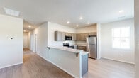 Located at 1666 W Cumberland Rd in Tyler, TX, this single-story, three-bedroom, one-bathroom home offers a well-designed layout with a clean, modern aesthetic. The open-concept kitchen and living area serves as the heart of the home, featuring a peninsula with granite countertops and seating, taupe shaker-style cabinetry extending to the ceiling, and a full suite of stainless steel appliances including a refrigerator, electric range, and over-the-range microwave. Light wood-style flooring runs throughout the main living areas, lending a bright and cohesive feel to the space.

The three bedrooms are thoughtfully sized, with the generously proportioned primary bedroom offering plush carpeting, a ceiling fan, and a walk-in closet. The additional bedrooms also feature carpet and windows that invite natural light and outdoor views of the surrounding landscape. The full bathroom is finished with a dark-cabinetry vanity topped with a granite-style countertop, a tub-shower combo, and matching light wood flooring. Throughout the home, neutral wall tones, recessed lighting, and clean white trim create a fresh, move-in-ready atmosphere well-suited for comfortable everyday living.