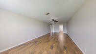 Located at 6860 Prutzman Rd in Beaumont, TX, this single-story 2-bedroom, 1-bathroom home offers a well-organized and functional layout across its single floor. Wood-look tile and plank flooring run consistently throughout every room, providing a cohesive and easy-to-maintain aesthetic. Neutral-toned walls and white trim complement the flooring and contribute to a clean, bright interior. The living room is generously proportioned, featuring a ceiling fan with light fixture and smooth flow into the rest of the home. The kitchen is well-appointed with white cabinetry, granite countertops, and a tile backsplash, alongside a dedicated utility area that houses a full-size washer and dryer with additional upper cabinet storage and exterior door access. The primary bedroom is a comfortable size, with a ceiling fan and a sliding glass door fitted with vertical blinds that allow natural light and outdoor access. The second bedroom is also well-sized with ample natural light. Each bedroom is served by its own closet. The bathroom features a full tub and shower combo, a white vanity with granite countertop, and additional overhead cabinet storage. The home's consistent finishes and practical layout make it a highly functional living space.