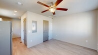 Located at 7547 Segundo Grove in Widefield, Colorado, this single-story one-bedroom, two-bathroom home offers a well-designed, efficient layout with modern finishes throughout. The open-concept living and kitchen area is bright and welcoming, featuring light wood-style flooring, neutral walls, and a ceiling fan with integrated lighting. A wall-mounted mini-split unit provides efficient climate control. The kitchen is a standout feature, centered around a large granite-topped island with a double-basin sink, complemented by white cabinetry, a stainless steel refrigerator, and a tile backsplash. Natural light flows in through a window overlooking the living area. The spacious primary bedroom is carpeted for comfort, complete with a ceiling fan, a sizeable sliding-door closet with arched panel doors, and easy access to the bathrooms. An additional room with light wood flooring and a window provides flexible use as a second living area or office. Both bathrooms are finished with granite vanity countertops and light wood-style flooring, with one featuring a full tub-shower combination. Clean, contemporary, and move-in ready, this home offers practical comfort in a compact, thoughtfully arranged floor plan.