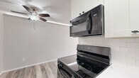Located at 1001 Seventh Ave SW in Forest Lake, Minnesota, this single-floor residence offers three bedrooms and one bathroom across a comfortable, efficiently designed layout. The updated kitchen is a standout feature, showcasing white shaker cabinetry, white quartz countertops, a classic subway tile backsplash, and black appliances including a refrigerator, electric range with over-the-range microwave, and dishwasher. A stainless steel sink with a modern matte black faucet completes the space. The open living area features light-toned laminate wood flooring, a textured ceiling, and a ceiling fan, with natural light streaming in through a large picture window. In-unit stacked washer and dryer add everyday convenience. The bedrooms are carpeted for comfort and include natural light from individual windows with roller shades and baseboard heating. The generously sized primary bedroom features mirrored sliding closet doors. The full bathroom is finished with white subway tile wainscoting, a white vanity with brushed nickel hardware, and a mirrored medicine cabinet. Neutral tones and clean finishes throughout give this residence a fresh, move-in-ready feel.