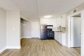 Located at 1040 Sandtown Rd SW in Marietta, Georgia, this single-floor, 1-bedroom, 2-bathroom unit offers a practical and well-appointed layout throughout. The living room is a bright, open space finished with wood-look plank flooring and neutral-toned walls, anchored by a sliding glass door that fills the room with natural light and provides direct access to a private outdoor patio and yard area. The kitchen is efficiently designed with white cabinetry, a black refrigerator and electric range, a built-in sink, and matching wood-look flooring that continues from the main living area. A dedicated closet is conveniently located just off the kitchen. The bedroom features soft carpeting, a window overlooking greenery outside, and a closet with open shelving. The hallway connects the living spaces to two bathrooms, each finished with wood-look tile flooring. One bathroom includes a vanity with a gray cabinet base, white countertop, and a bold black-framed mirror with overhead lighting. Clean white walls and consistent trim details are found throughout. The exterior features a concrete patio and a grassy backyard, offering usable outdoor space.