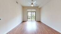Located along NASA Parkway in Houston, TX, this well-appointed one-bedroom, two-bathroom residence offers a thoughtfully designed single-floor layout. The open-concept living and kitchen area features warm hardwood flooring throughout, with a ceiling fan and sliding glass doors that lead to a private balcony overlooking lush greenery and the surrounding community.

The kitchen is a standout feature, showcasing rich dark-stained cabinetry, granite countertops, a classic subway tile backsplash, and a full suite of stainless steel appliances including a gas range, built-in microwave, refrigerator, and dishwasher. A kitchen island with a white countertop adds additional prep space and a clean contrast to the cabinetry.

The spacious primary bedroom is carpeted for comfort, equipped with a ceiling fan, and features a large window with views of mature trees. It connects to a generous walk-in closet outfitted with multi-level wire shelving and hanging rods. The en-suite primary bathroom is elegantly finished with floor-to-ceiling marble-style tile, a soaking corner tub, a glass-enclosed walk-in shower, and a vanity with a granite countertop. A second bathroom provides additional convenience for guests.